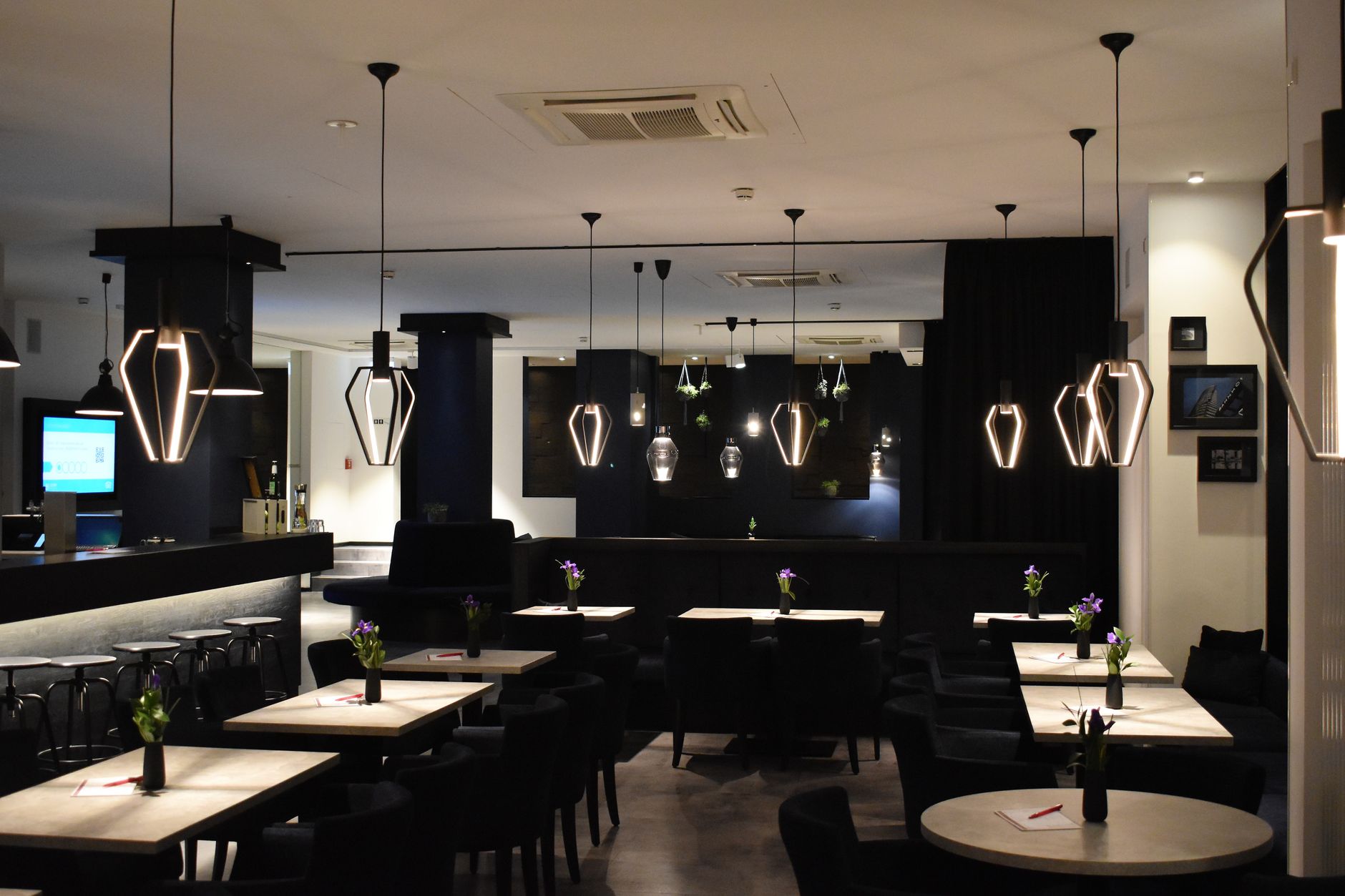 Stylish and contemporary dining area featuring geometric pendant lights.